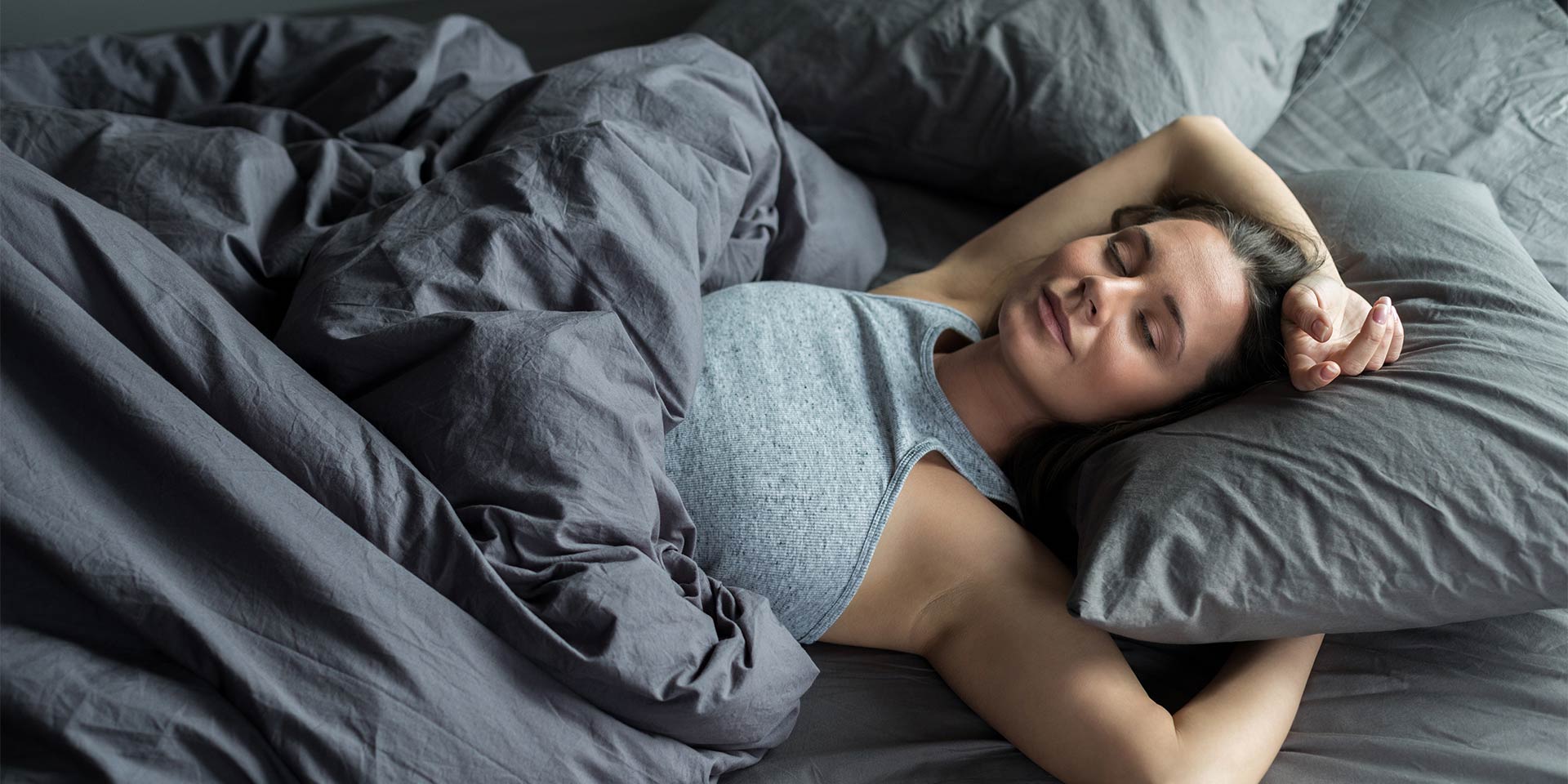 frau schläft entspannt im bett