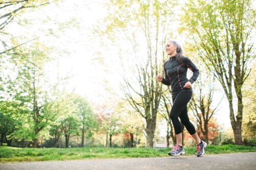 Frau joggt in der Sonne. Gelenkgesundheit