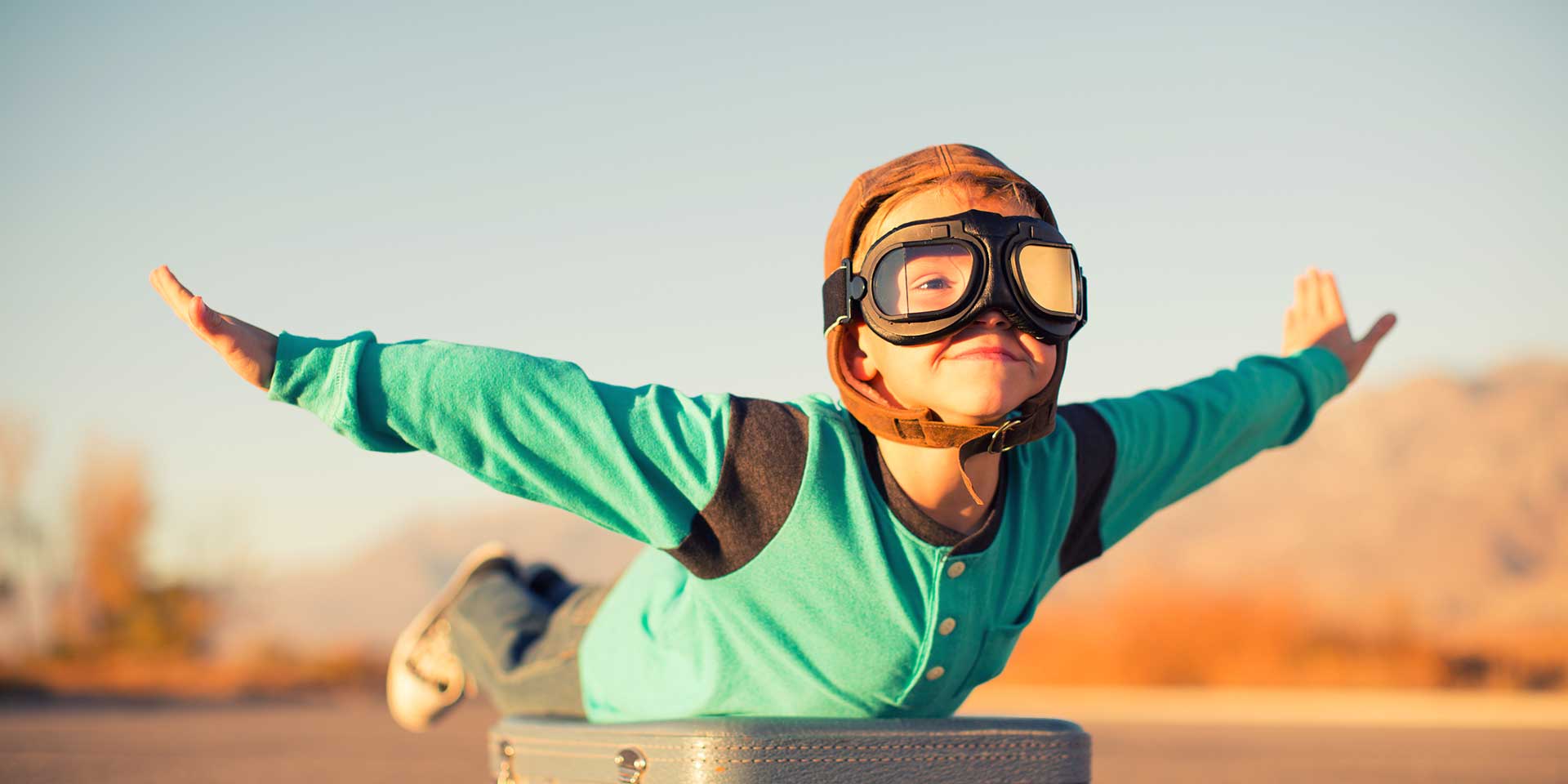 kind spielt flugzeug  pilotenkappe  -brille. zukunftstauglichkeit