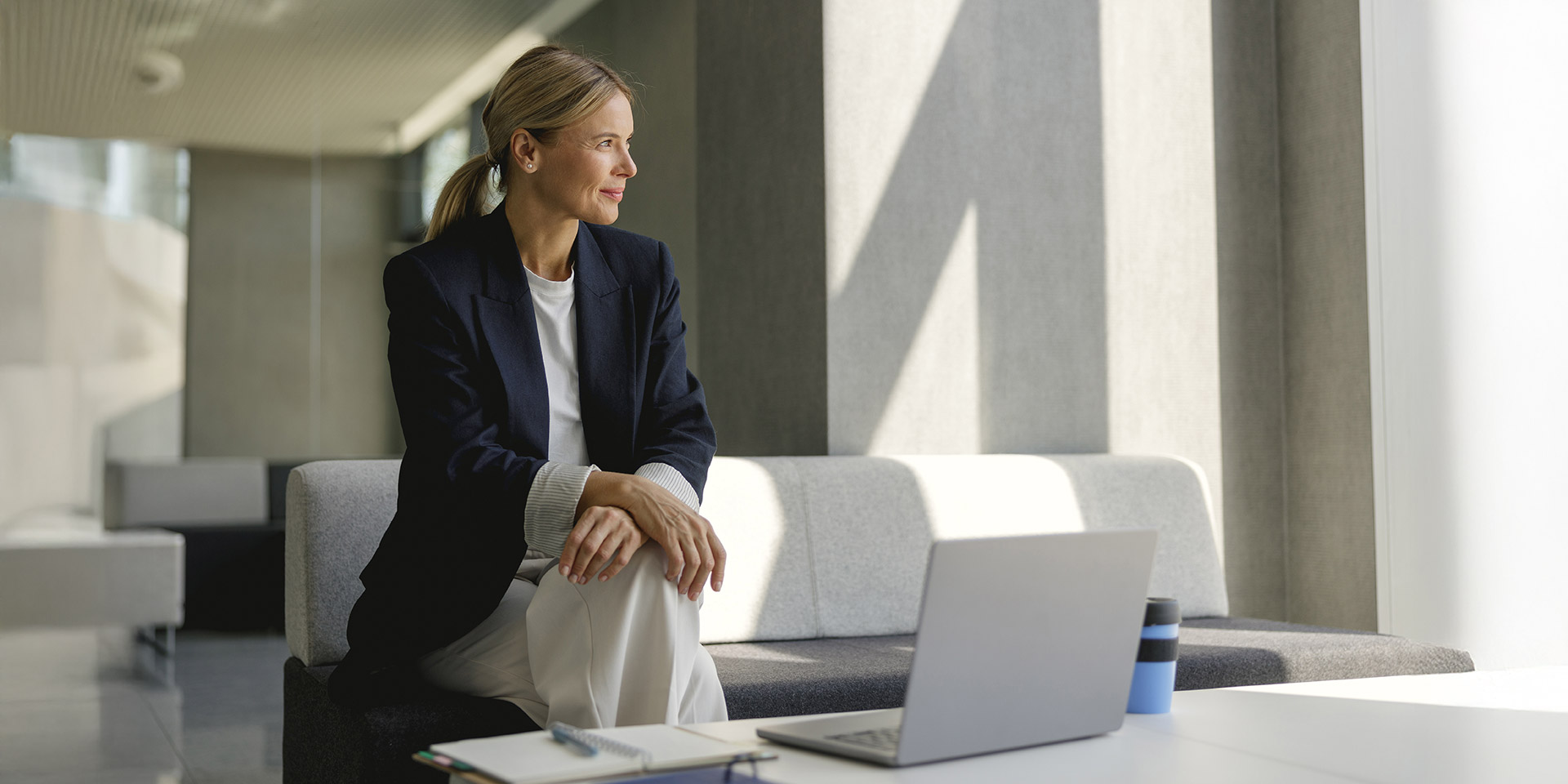 pretty female entrepreneur rking on laptop sitting in mon office hall and looks away stock photo. symbolbild demokratie lebt von vielfalt