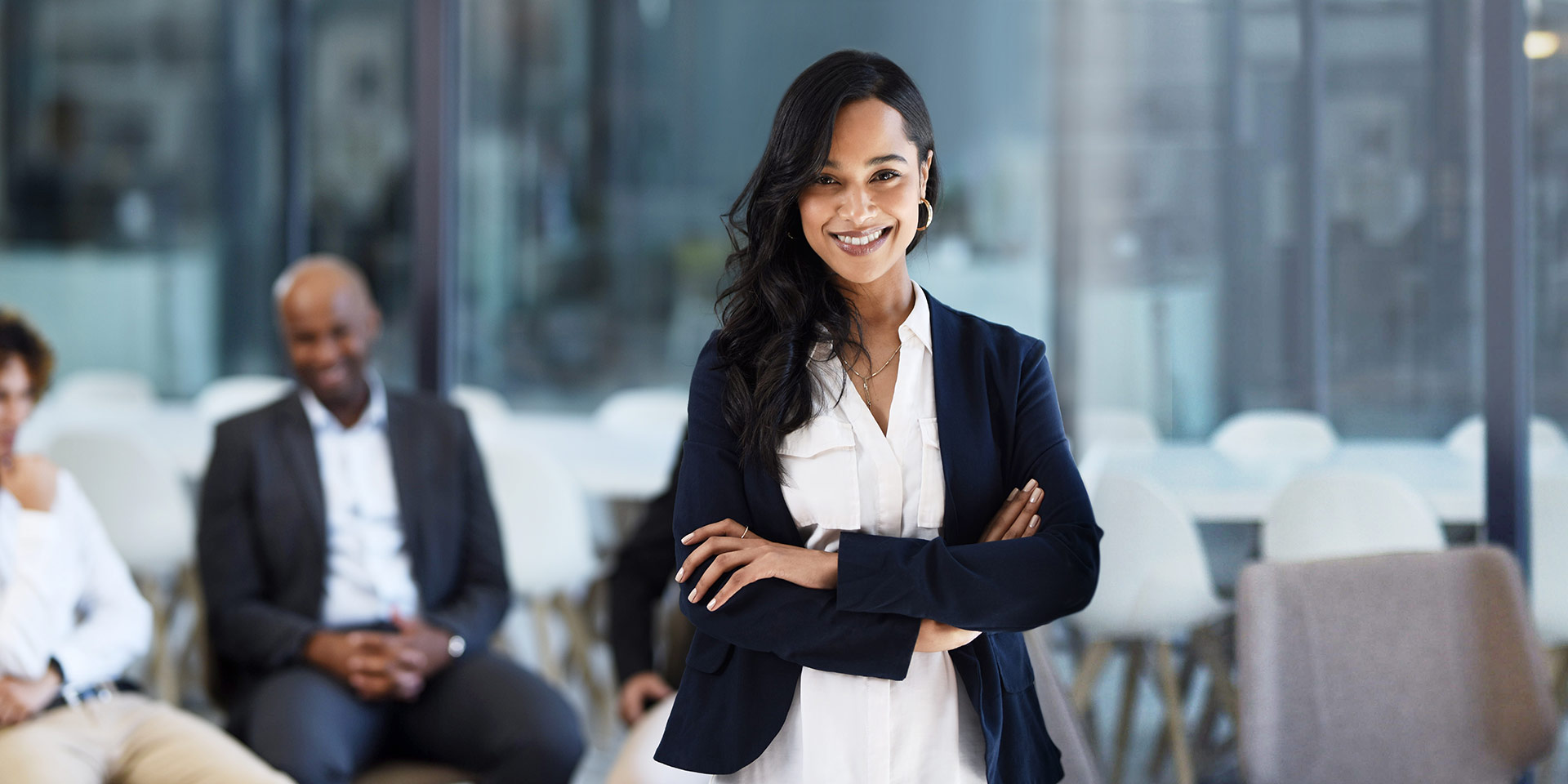 cropped shot of an attractive young businessman standing with her arms crossed with her colleagues in the backgro. symbolbild frauen in führungspositionen