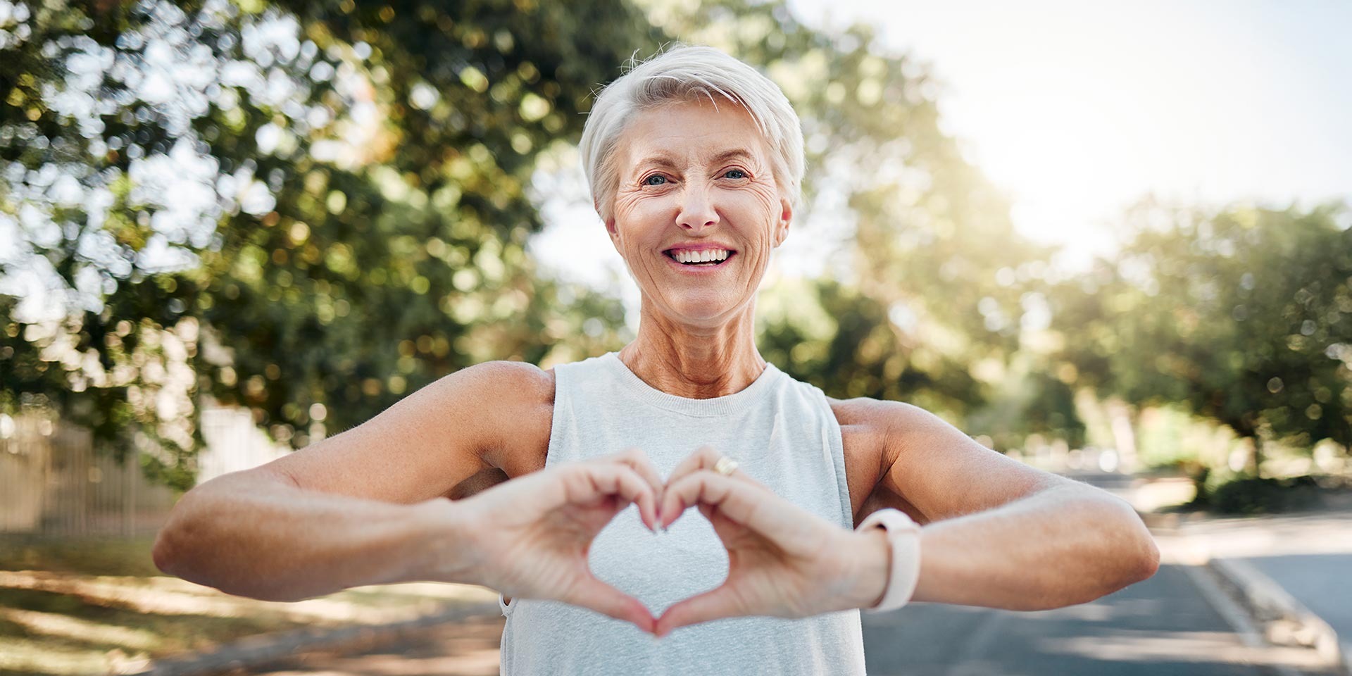 fitness, happy and heart hands of old man in nature after running for health, wellness and rkout. smile, motivation and peace with senior lady and sign for love, faith and training in nature stock photo. symbolbild unsichtbare krankheiten, hormone