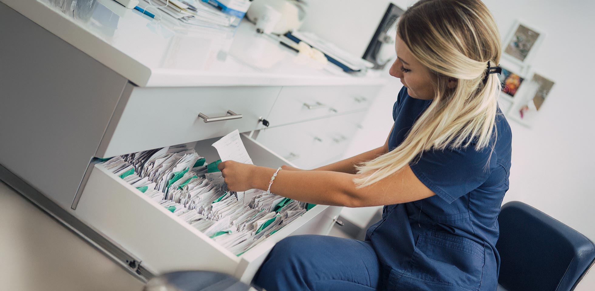 nahaufnahme  hände einer frau,  patientenakten ordnet. symbolbild effizienzsteigerung durch digitale tools