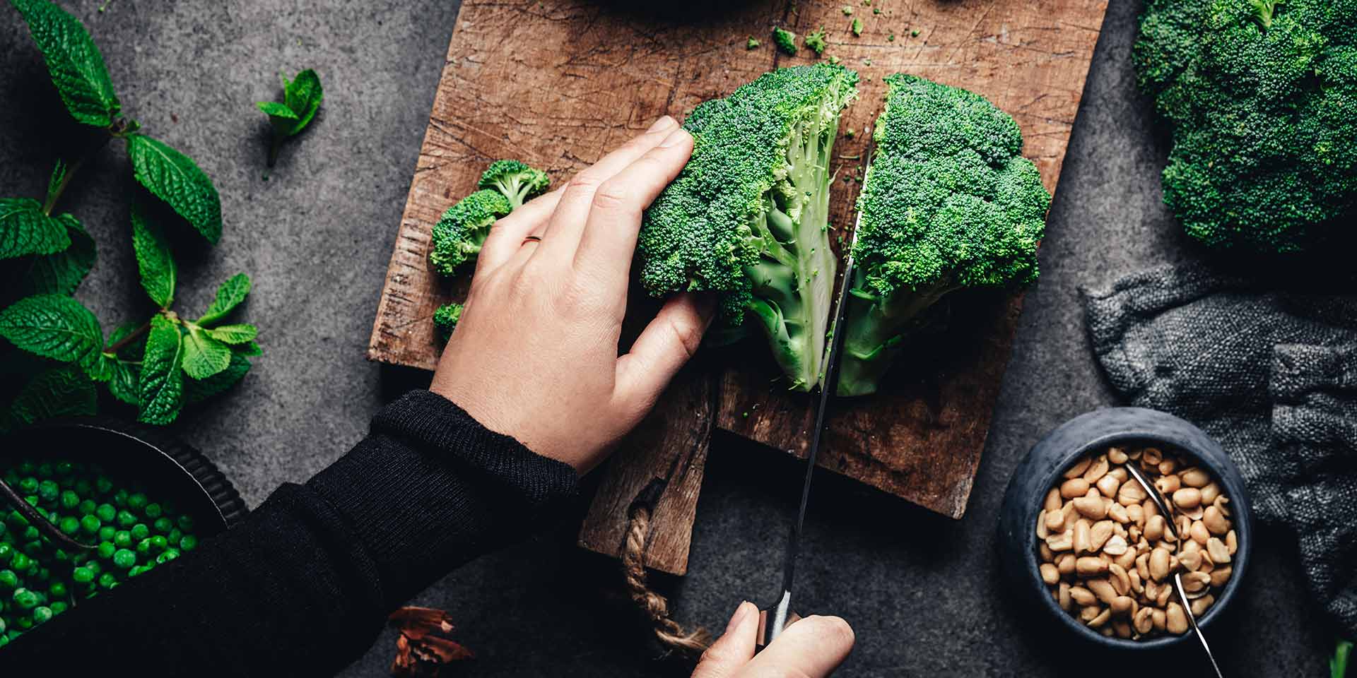 woman cutting fresh broccoli stock photo