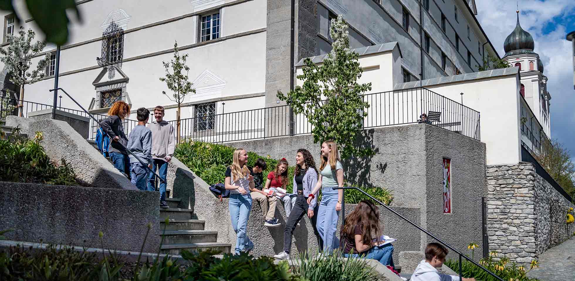 jugendliche vor dem gymnasium & internat kloster disentis