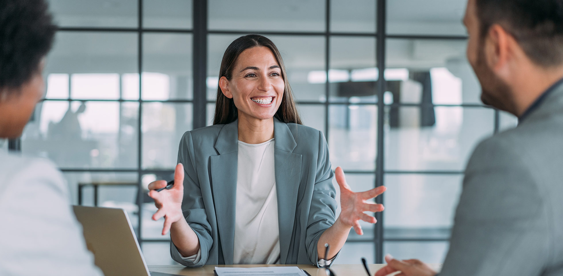 aufnahme einer gruppe von geschäftsleuten bei einem geschäftstreffen. drei unternehmer bei einer besprechung im sitzungssaal. unternehmens-team bei einer besprechung in einem monen büro. managerin bespricht neues projekt  ihren kollegen. firmeninhaberin bei einer besprechung  zwei ihrer mitarbeiter in ihrem büro. symbolbild partnerinnen