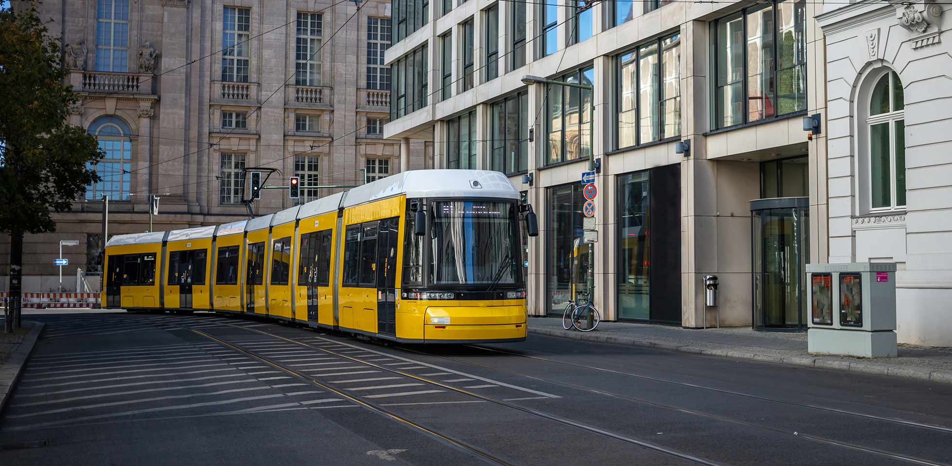 konzept für den öffentlichen nahverkehr. gelbe elektrische straßenbahn fährt durch  stadt berlin, deutschland. stadtkulisse, banner. symbolbild kritische infrastruktur