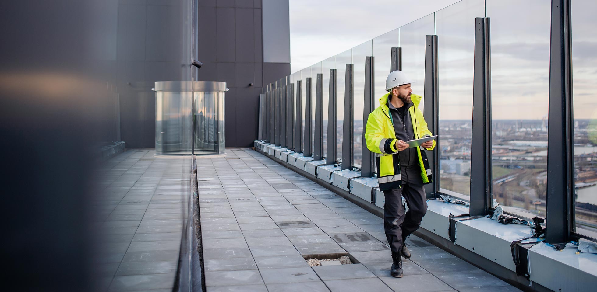 älterer ingenieur,  auf einer baustelle geht  ein tablet  bauplänen in  hand hält. symbolbild bau von morgen