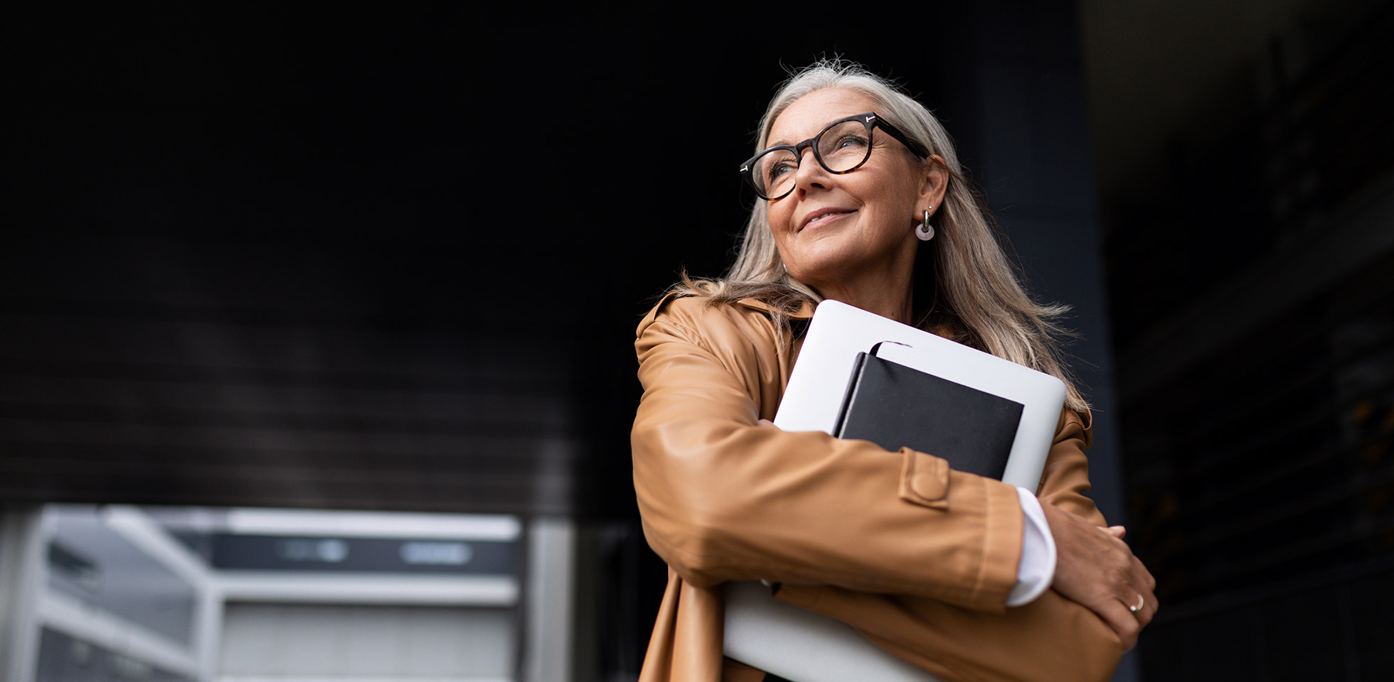 erfolgreicher kaukasischer geschäftsmann  laptop  terminkalen in den händen, brille, vor dem hintergr eines bürogebäudes im freien.