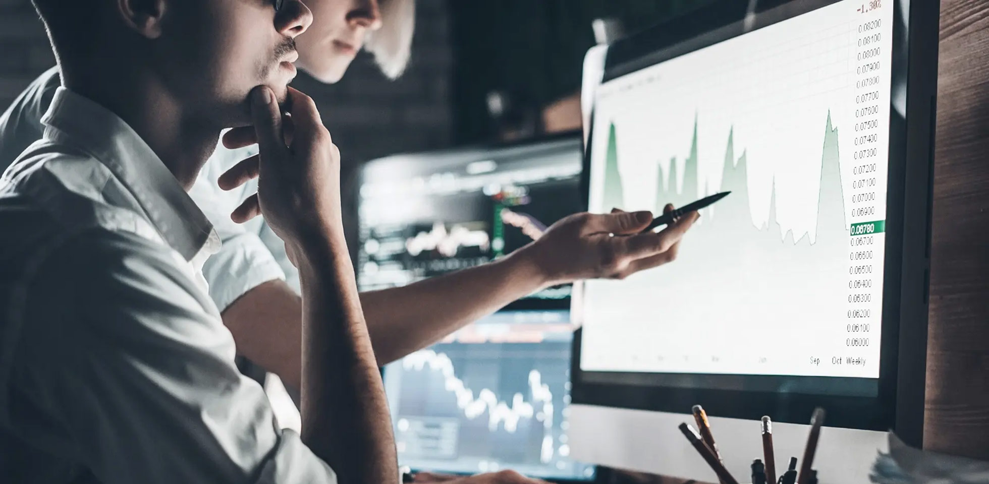 zwei personen diskutieren finanzdaten auf einem monitor. symbolbild fremdfinanzierung von immobilien