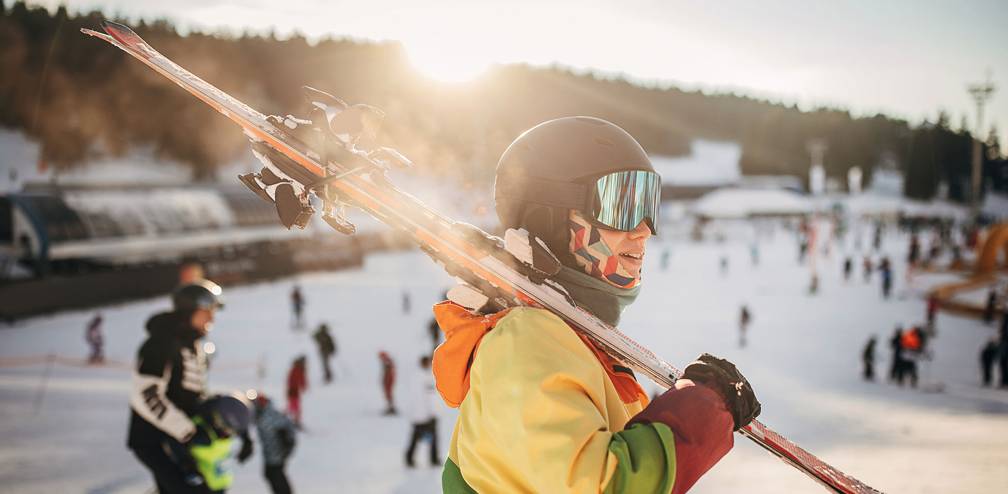 skifahrerin steht auf einem hügel  trägt ihre skier in einem schneebedeckten skigebiet in den bergen.