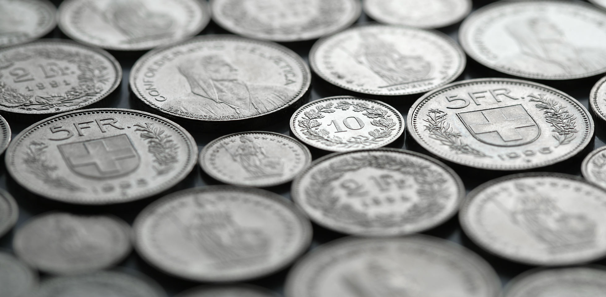 schweizer münzen liegen in einem regelmäßigen muster. selektiver fokus. symbolbild lohngleichheit schweiz