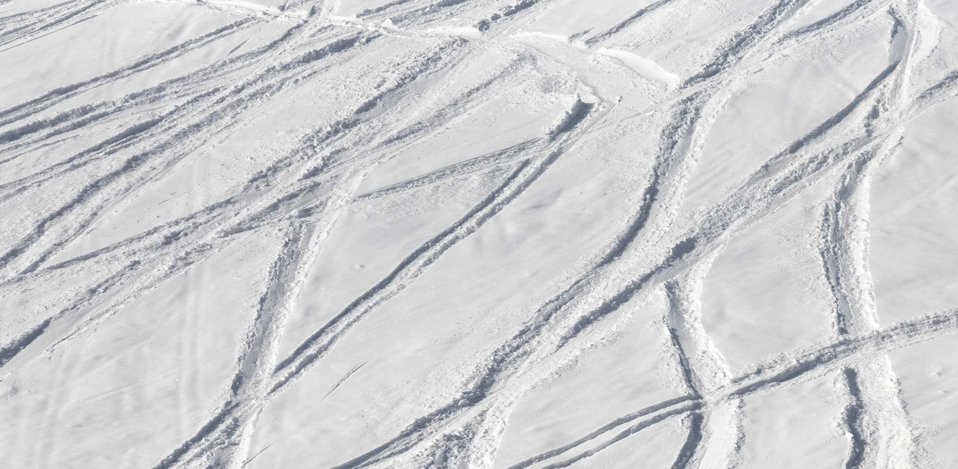 verschneite off-piste-skipiste  spuren von skiern  snowboards an einem sonnigen wintertag. symbolbild schweizer winterparas