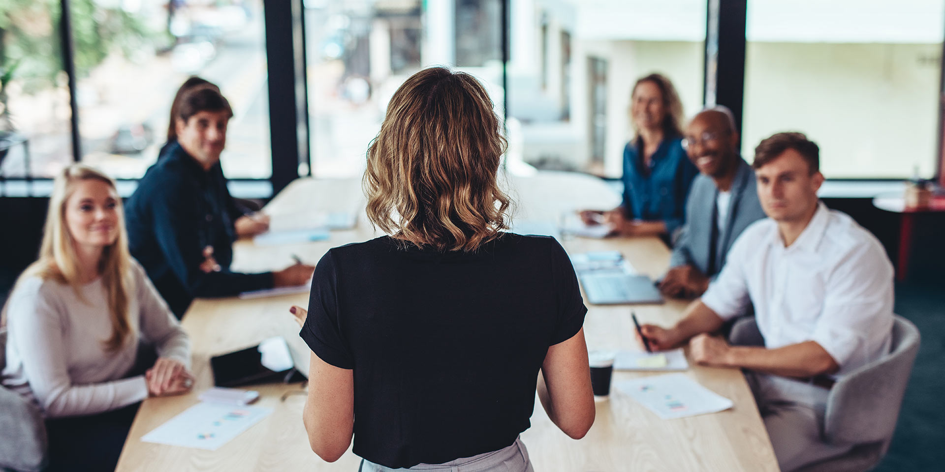 rear view of a businessman addressing a meeting in office. female manager having a meeting with her team in office boardroom.