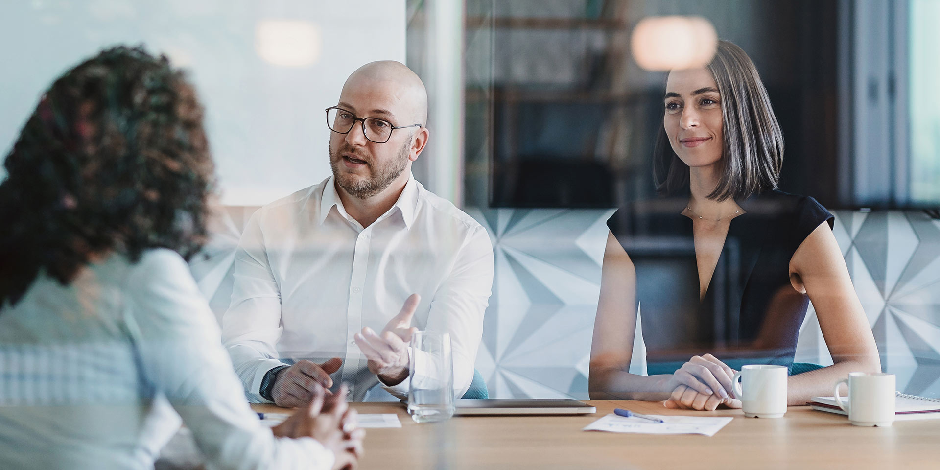 group of business persons having a meeting behind a glass wall, erbe