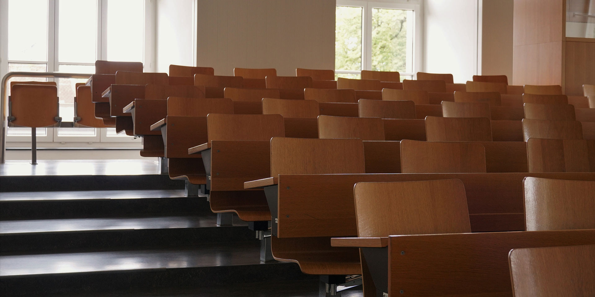 leeres auditorium an  universität  holzstühlen  bänken so großen fenstern  treppen auf einer seite, lernen