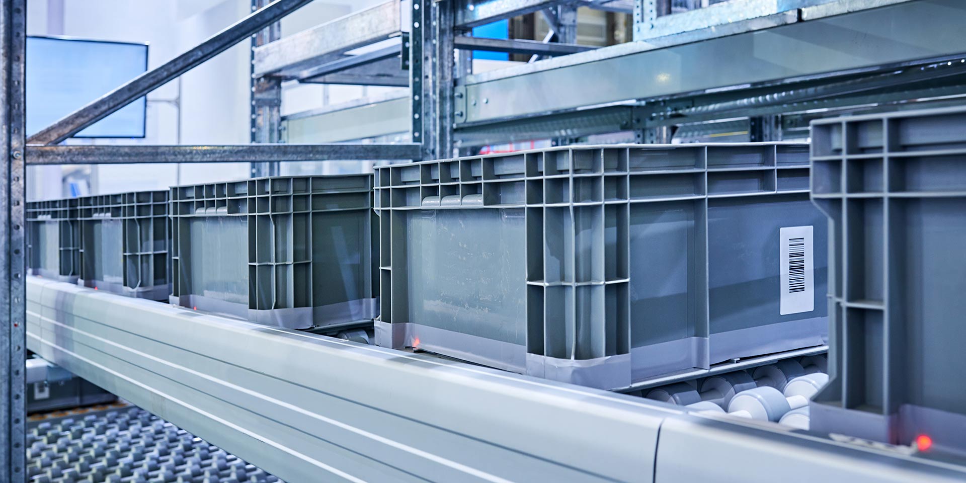 side view of plastic crates at conveyor belt. intralogistik
