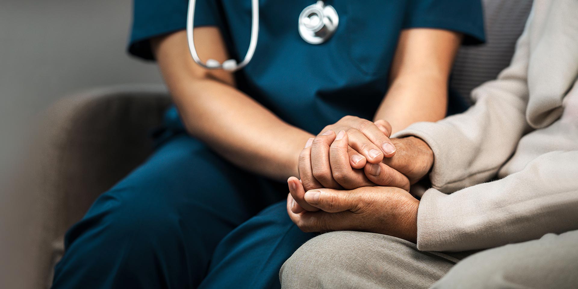 a female nurse caregiver holds hands to encourage and comfort an elly man. for care and trust in nursing homes for people of retirement age caregiver helping elly man provides medical advice, ausbildung